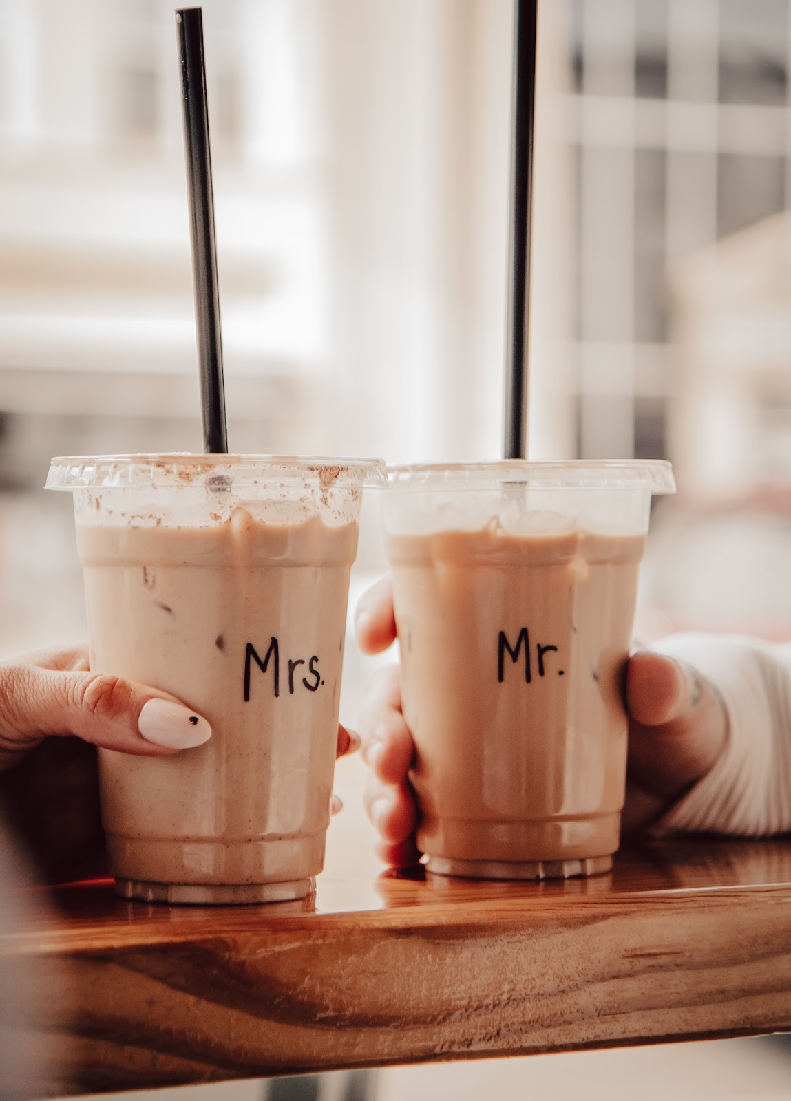Two iced drinks labelled Mr. and Mrs. held over the wooden bar