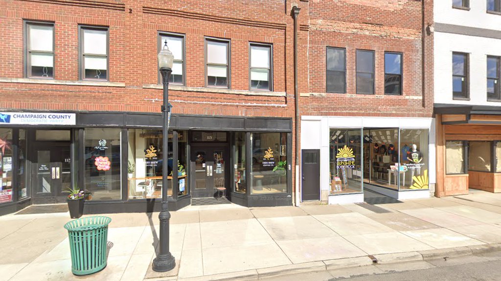 The black storefront of Dees Brew Coffee Co. at 113 N Main Street in a red brick block downtown